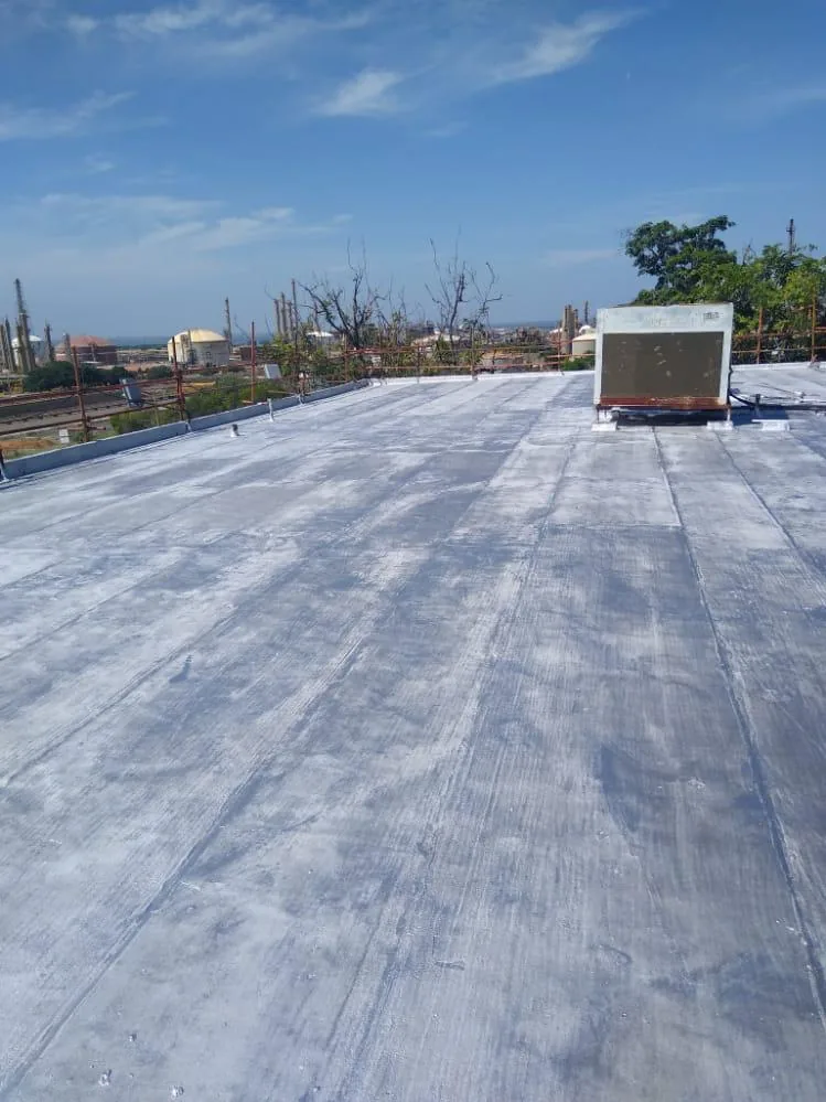 Techo impermeabilizado con vista a planta industrial al fondo