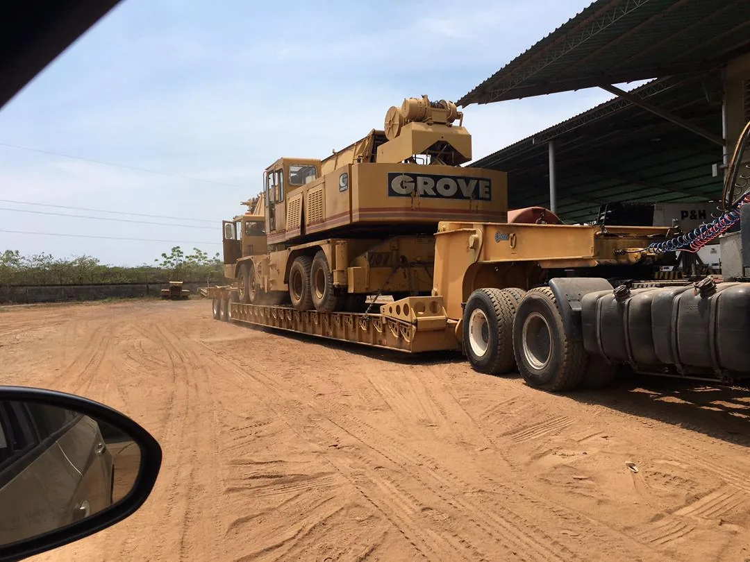Grúa Grove cargada en lowboy trailer en patio de equipos